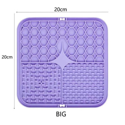 Dog licking treats on a silicone lick mat